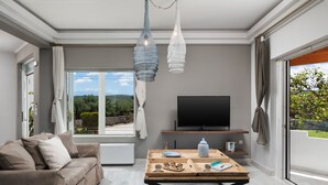 Un saló modern amb un sofà, una taula de centre i una televisió.
