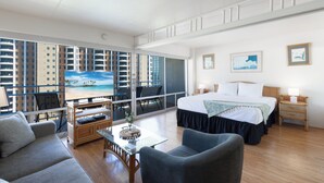 A spacious hotel room with a large bed, a balcony with a view of the city, a television, and a dining area. - Beautiful Lagoon View At The Ilikai Hotel!  One-bedroom Fully Re-Modeled Unit A++ (Honolulu)