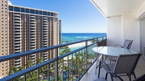 A balcony with a glass table and chairs, overlooking a beach and a resort area. - Beautiful Lagoon View At The Ilikai Hotel!  One-bedroom Fully Re-Modeled Unit A++ (Honolulu)
