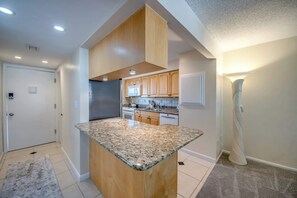 Eine moderne Küche mit Granit-Arbeitsplatten, Holzschränken und einer eingebauten Mikrowelle.