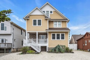 A two-story house with a front porch, a small staircase, and a garage.