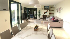 A modern living room with a marble dining table, a sofa, and a television.