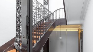 Eine Treppe mit schmiedeeisernem Geländer und Holzstufen.