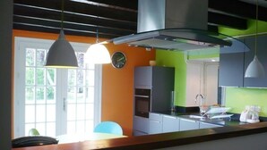 Una cocina moderna con un amplio ventanal, un lavamanos y un reloj en la pared.