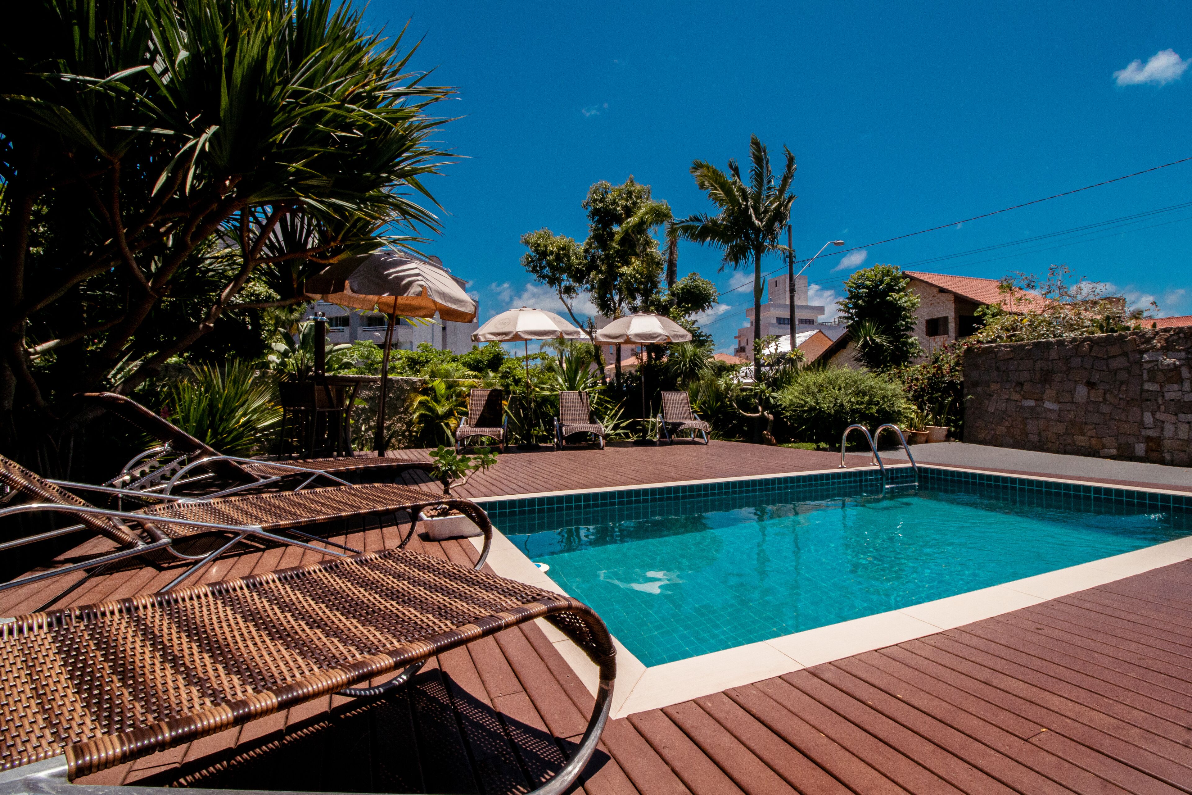 Una piscina al aire libre, camas de piscina gratis, sombrillas