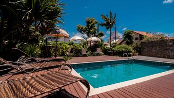 Una piscina al aire libre, camas de piscina gratis, sombrillas