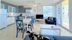 Un apartamento moderno con cocina, comedor, sala de estar y ventanas amplias.