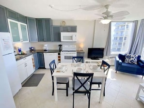 A compact living space with a kitchenette, dining area, and a seating area with a view.