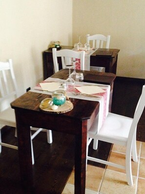 A dining table set with white chairs, a wooden table, and a decorative centerpiece. - La Timpa del Cucco (Roccagloriosa)