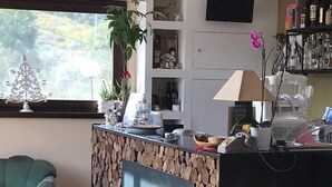 A reception desk with a stone facade, a green armchair, and a potted plant. - La Timpa del Cucco (Roccagloriosa)