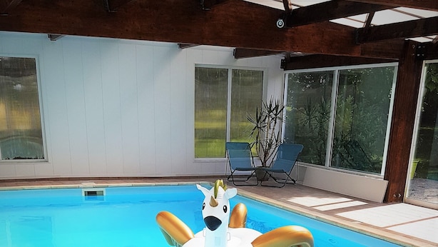 Una piscina interior con un juguete inflable con forma de cisne.