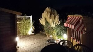 A patio area with outdoor seating, a small table, and a decorative plant.