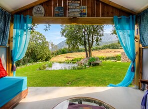 A room with a view of a grassy area, a pond, and trees. - Homerez - Apt. in Moltifao, great view. (Moltifao)