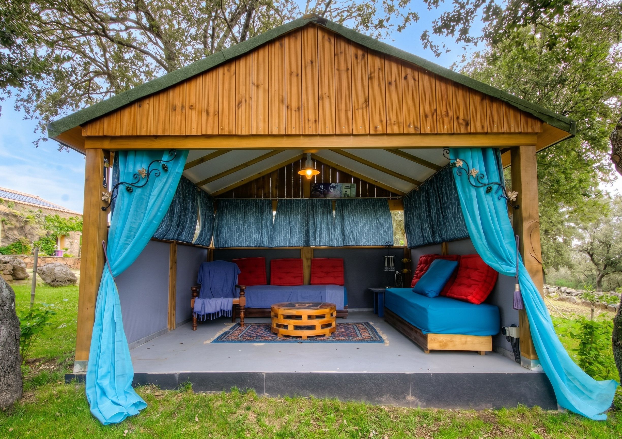 A wooden cabin with a covered porch, a bed, a sofa, and a small table.