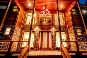 Stunning two-story building with a grand entrance and wooden door, featuring a staircase leading up to it.