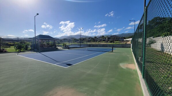 An outdoor tennis court with a pavilion, surrounded by a chain-link fence and greenery. - "LuxuryCrest: King Bed, BBQ & Backyard Games, Near Ocho Rios"
(Priory)