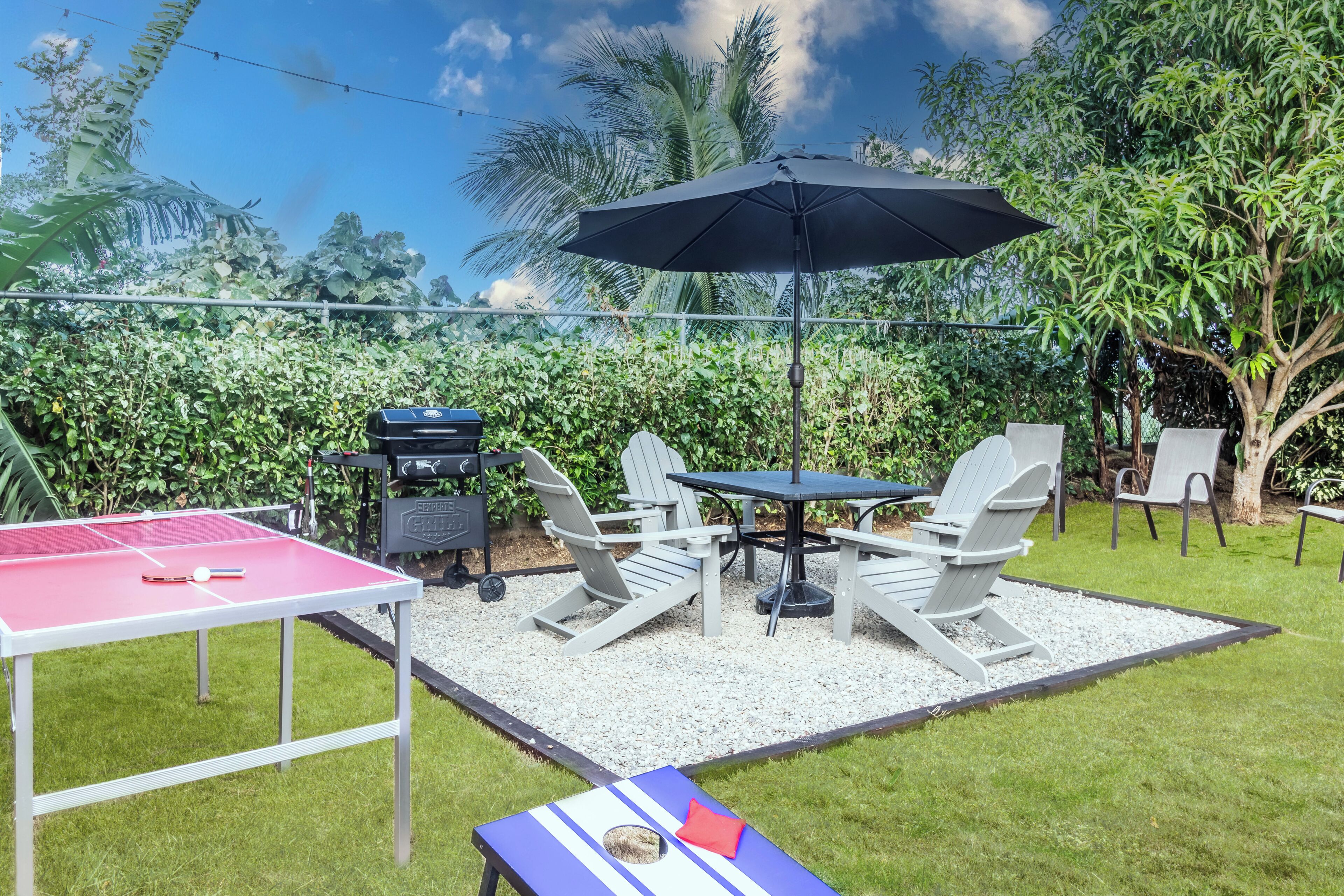 Un patio con mesa de ping-pong, mobiliario exterior y zona de barbacoa.