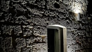 Un muro de piedra con una puerta y una silla al frente.