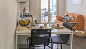 A compact living space with a dining area, a kitchenette, and a seating area with a sofa and chairs.