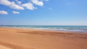 A beach with a clear sky and calm sea.