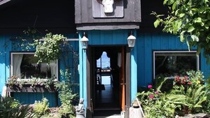Un bâtiment bleu avec une enseigne portant l’inscription « ADELE’S » et une statue en pierre à l’entrée.