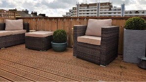 A rooftop terrace with wicker furniture and potted plants. - Stunning Grade II listed Holiday Home in St Leonards On-Sea (Saint Leonards-on-sea)