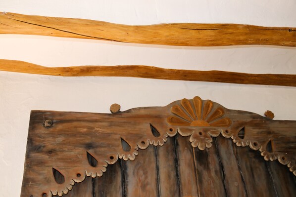 A wooden panel with a decorative design, featuring a scalloped edge and a central fan-like pattern.