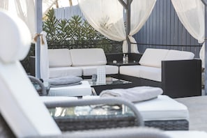 A modern outdoor seating area with a sofa, chairs, and a table.