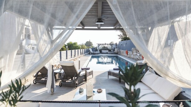 An outdoor pool area with lounge chairs and a pergola. - Villa Parisi Naxos Deluxe 1 (Agkidia)