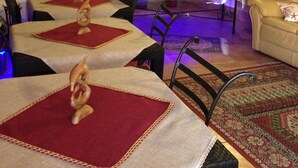 A dining area with tables covered in red and white tablecloths, chairs, and decorative items. - Villa Verdesca (San Vito Lo Capo)