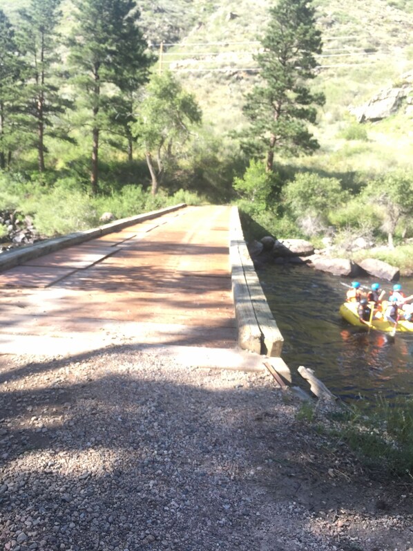 A gravel path leading to a bridge over a river, surrounded by trees. - Iconic Red House at red house hole! (Bellvue)