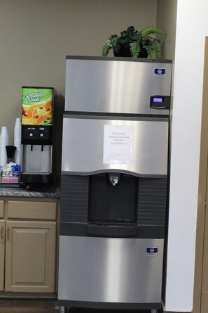 Un refrigerador de acero inoxidable con dispensador de agua y una nota en la puerta.