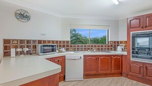 A kitchen with a microwave, dishwasher, and stove. - Ocean Waves - Downtown Oceanfront (Lennox Head)