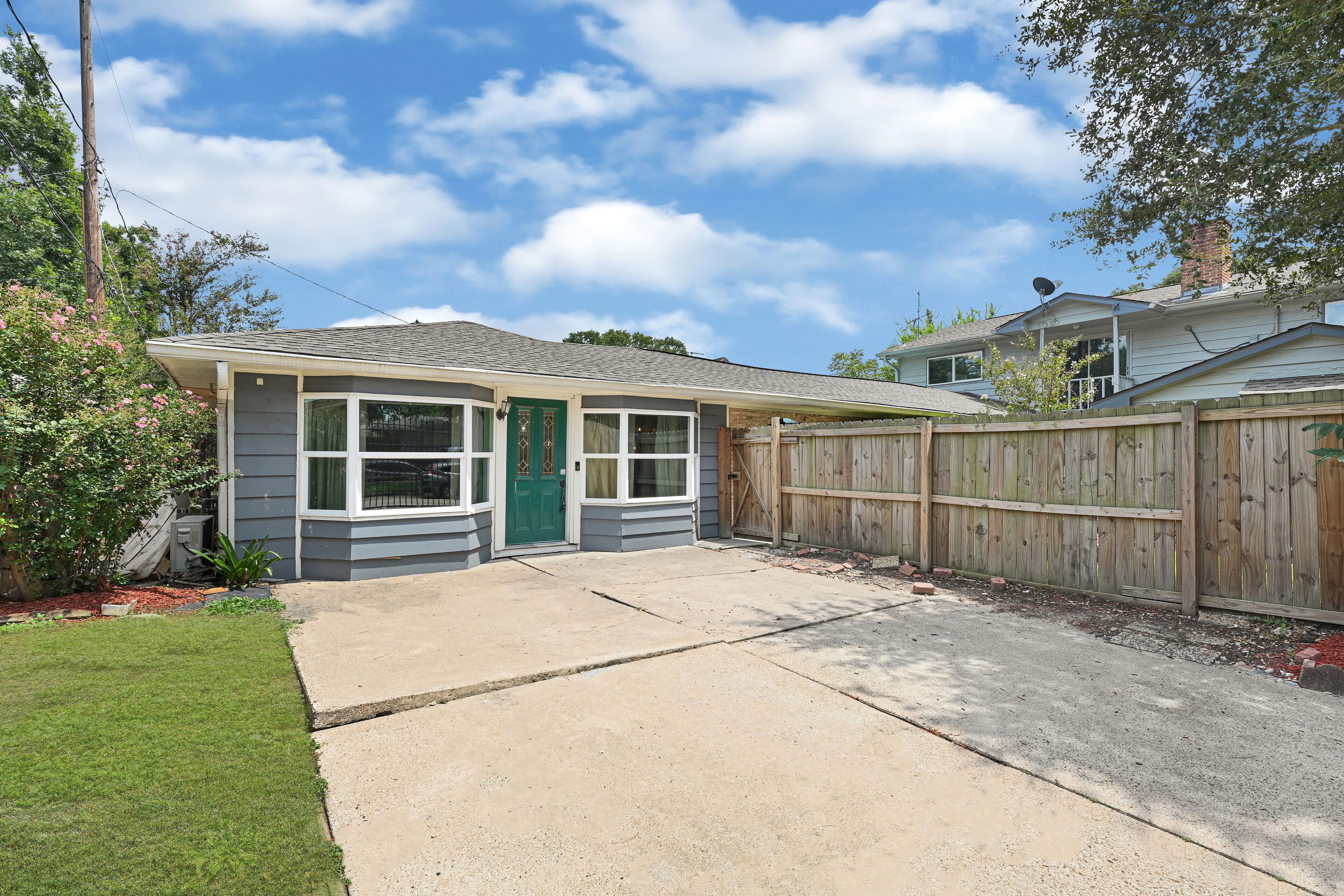 A residential house with a front yard, a wooden fence, and a garage.