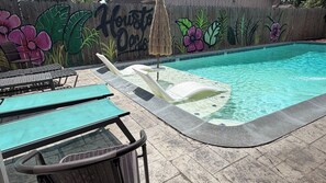 A swimming pool with lounge chairs and a mural on the wall. - Private Retreat w/ Pool, Patio, BBQ! 6BR 3BA Gem (Houston)