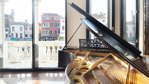 A grand piano in a room with large windows overlooking a cityscape. - Palazzetto Foscari (Venice)