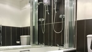 A modern bathroom with a glass-enclosed shower, a white sink with a towel, and a toilet. - No14 in the heart of St Andrews (St Andrews)