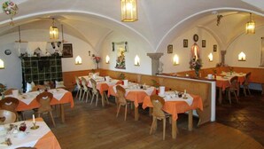 A restaurant with tables set for dining, wooden chairs, and a bar area. - Apartment 11 with balcony and terrace, 30 m² (Soyen)