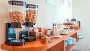 A kitchen counter with two coffee grinders, a coffee pot, and various food items. - A' Coffa (Taormina)