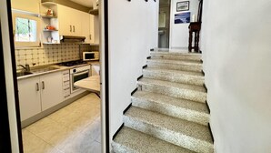 A kitchen with white cabinets, a microwave, and a stove.
