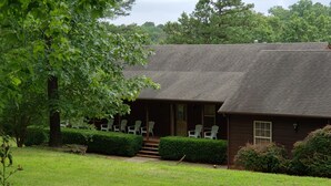 A two-story building with a porch and outdoor seating.