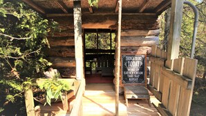 L’entrée d’un chalet en bois, avec une pancarte indiquant les activités proposées, comme se réveiller, manger une glace et faire la sieste.