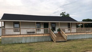 A two-story house with a covered porch and a wooden staircase leading to the front door. - 3br2bath farmhouse 7min d'town Mem ❤️1 pet free 2nd pet considered for fee  (Mound City)