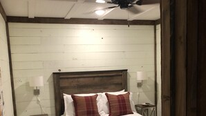A bedroom with a wooden headboard, two bedside lamps, a small nightstand, and a ceiling fan. - 3br2bath farmhouse 7min d'town Mem ❤️1 pet free 2nd pet considered for fee  (Mound City)