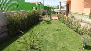 A well-maintained garden with a variety of plants and a neatly trimmed lawn. - Attic overlooking the sea of the Cyclops (Vampolieri)