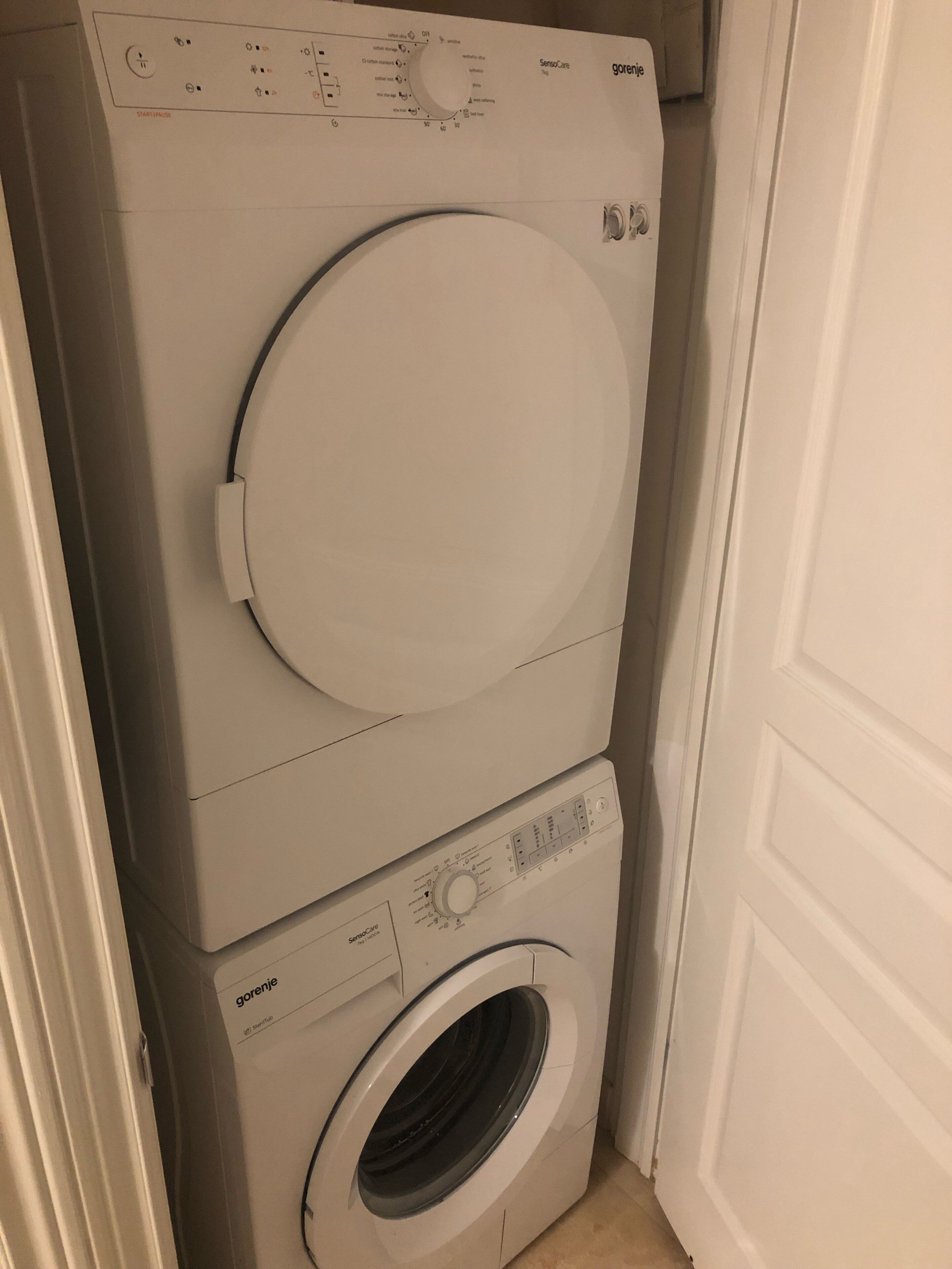A stacked washer and dryer unit with control panels and a door.