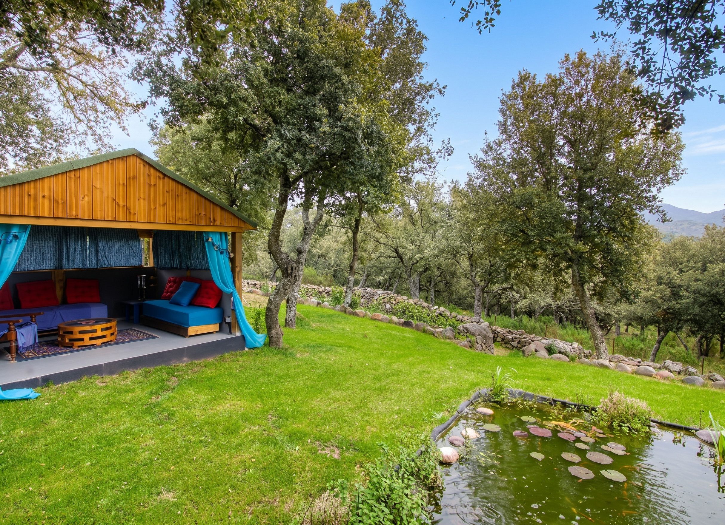 Un rustico chalet in legno con un angolo salotto integrato e uno stagno ricoperto di ninfee.