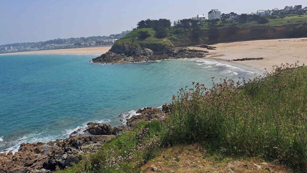 A coastal landscape with a rocky shoreline, a sandy beach, and a hill with buildings. - Homerez - House in Saint-Alban (Saint-Alban)