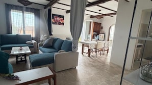 Una sala de estar con un sofá, una mesa de centro y un comedor con mesa y sillas.