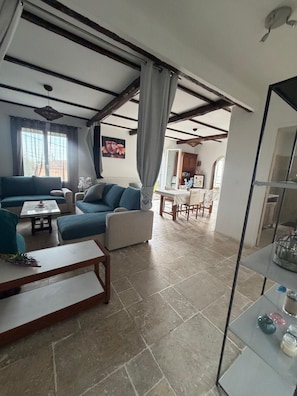 A living room with a sofa set, a coffee table, and a dining area with a table and chairs.